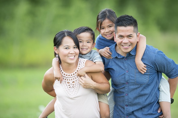 A family of four smiling to the camera