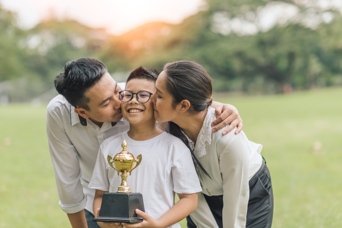 parents-kissing-kid-cheeks